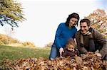 Couple et leur fille jouant avec feuilles