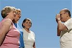 Senior man photographing three senior women