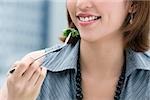 Close-up of a young woman eating salad