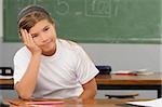 Portrait of a schoolgirl thinking in a classroom