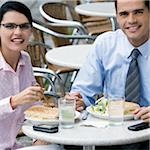Portrait d'un homme et une femme d'affaires en train de déjeuner dans un café de trottoir
