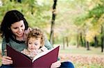 Mid adult woman looking at a picture book with her daughter