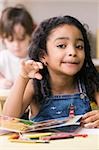 Portrait of a girl making a face with a boy sitting behind her