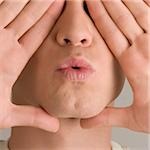 Close-up of a young man covering his eyes with his hands