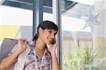 Jeune femme parlant sur un téléphone mobile et souriant