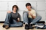 Portrait of two high school students sitting in front of lockers