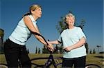 Two senior women standing with bicycles