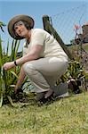 Senior Woman Hecke Clippers in einem Garten mit