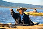 Fischer auf einem Boot und zeigt einen Fisch, Insel Janitzio, Lake Patzcuaro, Patzcuaro, Bundesstaat Michoacan, Mexiko