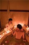 Young woman taking bath with flower petals