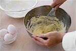 A woman mixing flour and egg