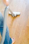 A woman cleaning floor with vacuum cleaner, blurred motion