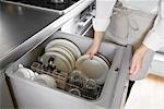 A woman loading dishwasher