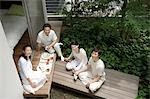 A family with adult children having lunch in porch