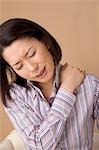 A woman suffering from pain in shoulder