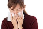 A young woman blowing nose on tissue