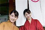 Two young women standing in front of restaurant