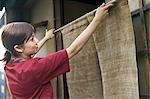 Young woman hanging store curtain