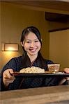 Young woman receiving a tray of noodles