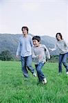 Family running in meadow