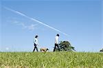 Young couple walking dog