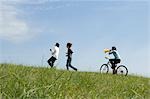 Junge Frau Fahrradfahren hinter zwei junge Männer, die unter