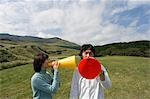 Young couple shouting into megaphones