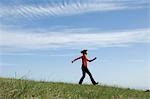 Young woman skipping in field