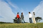 Four young people standing in field