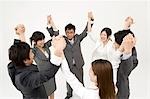 Business people standing in circle holding hands