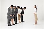 Business people bowing to businesswoman