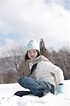 Young woman sitting in snow