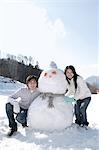 Young couple with snowman