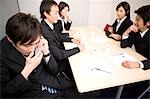 Young businessman using mobile phone during meeting