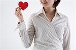 Businesswoman holding heart-shaped paper