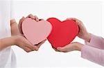 Man and woman holding heart-shaped boxes