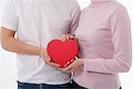 Man and woman holding heart-shaped box