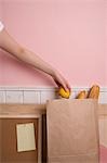 Woman's hand putting lemon in paper bag