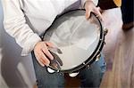 Young woman playing tambourine