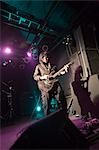 Young man playing electric guitar on stage