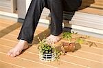 Potted plants beside young woman's feet