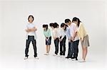 Group of people bowing to a young man