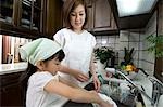 Mother and daughter washing dishes