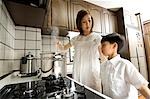 Mother and son cooking in kitchen