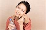 Young woman wiping face with towel