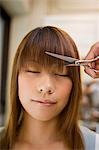 Young woman getting bangs cut