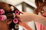 Hairdresser putting curlers in customer's hair