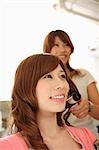 Hairdresser drying woman's hair