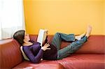 Schwangere Frau Lesebuch während liegend auf der Couch