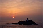 Phare sur la roche dans la mer au coucher du soleil au Point de Godrevy, Cornwall, Angleterre, Royaume-Uni, Europe